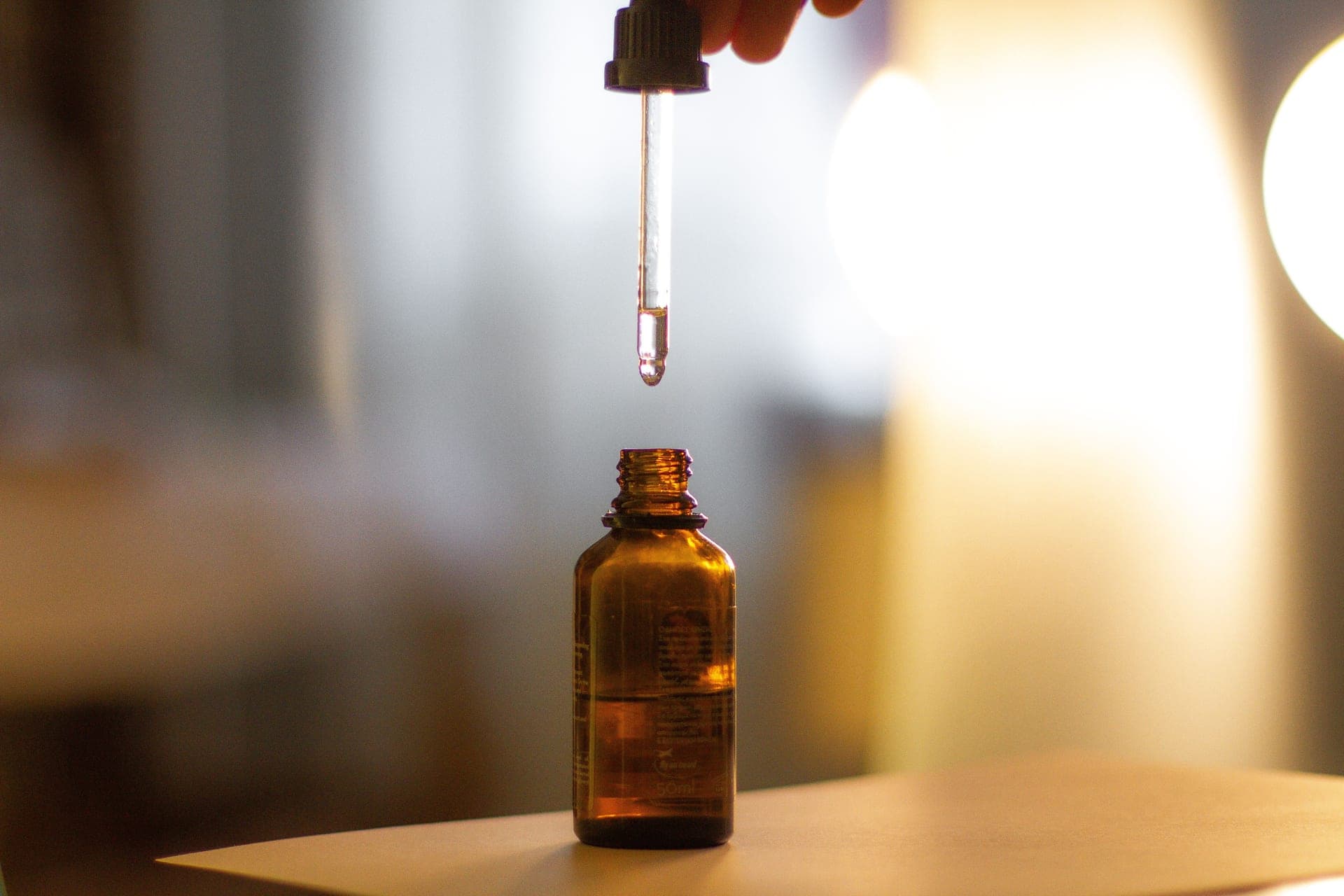A single serum droplet catching the light on a clean surface