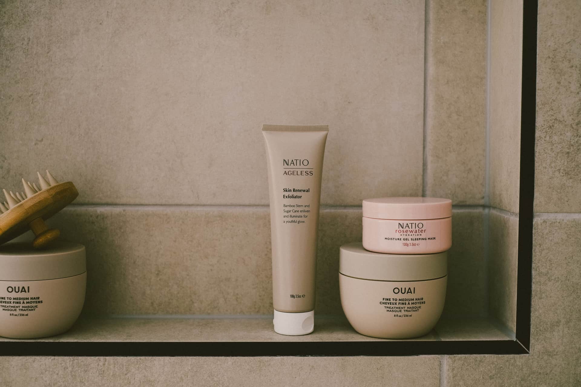 A small shelf of unbranded skincare bottles in soft morning light